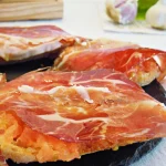 De jamón ibérico con tomate untado en el pan y aceite de oliva virgen